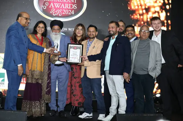 The Sai Surbhi team on stage at the Asian Restaurant Awards 2024 holding a winner certificate